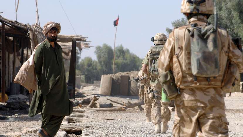 British Army Gurkha soldiers patrol through a deserted market street in southern Helmand