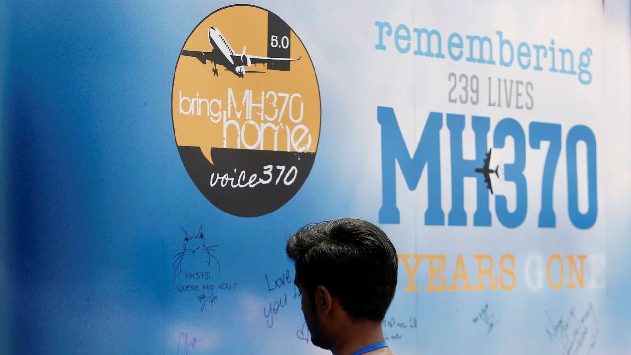 A man writes on a message board for passengers, onboard the missing Malaysia Airlines Flight MH370, during its fifth annual remembrance event in Kuala Lumpur