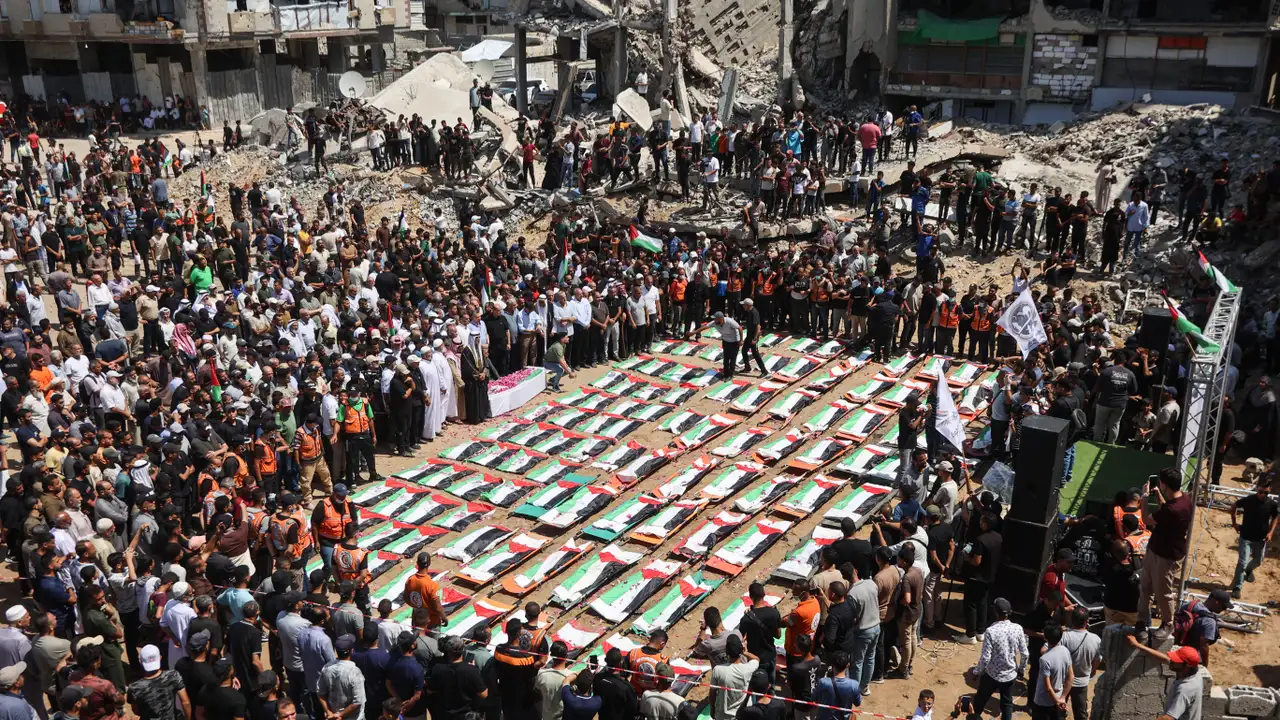 Palestinos participam do funeral coletivo de 112 pessoas, cujos corpos foram retirados dos escombros de prédios atingidos por bombardeios em novembro de 2023.