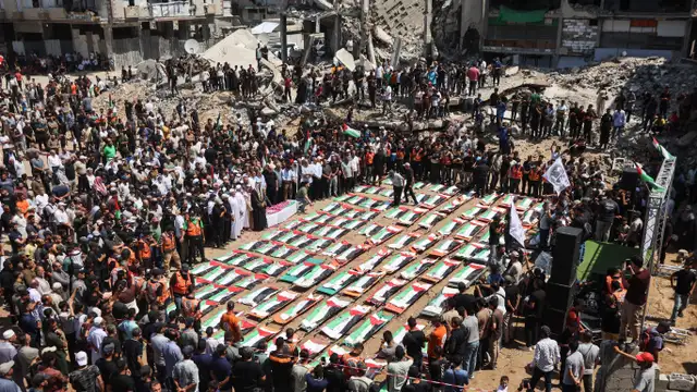 Palestinos participam do funeral coletivo de 112 pessoas, cujos corpos foram retirados dos escombros de prédios atingidos por bombardeios em novembro de 2023.