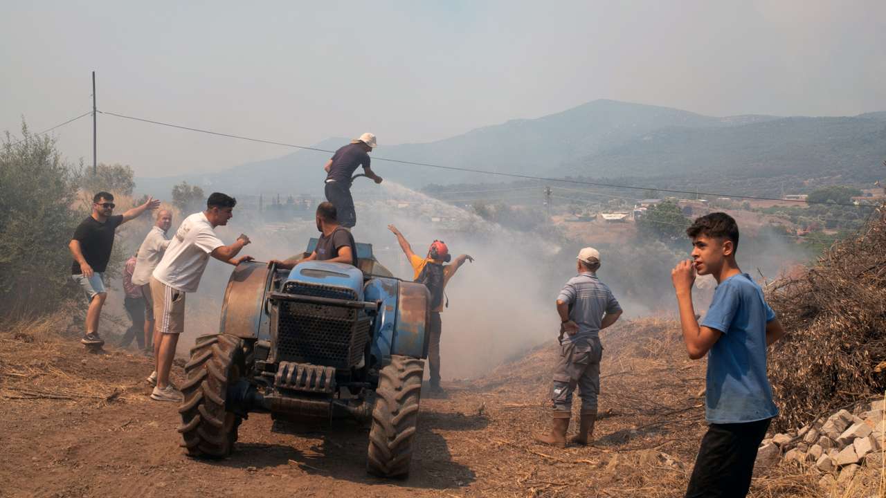 People respond to a wildfire in a village near Seferihisar in Izmir province
