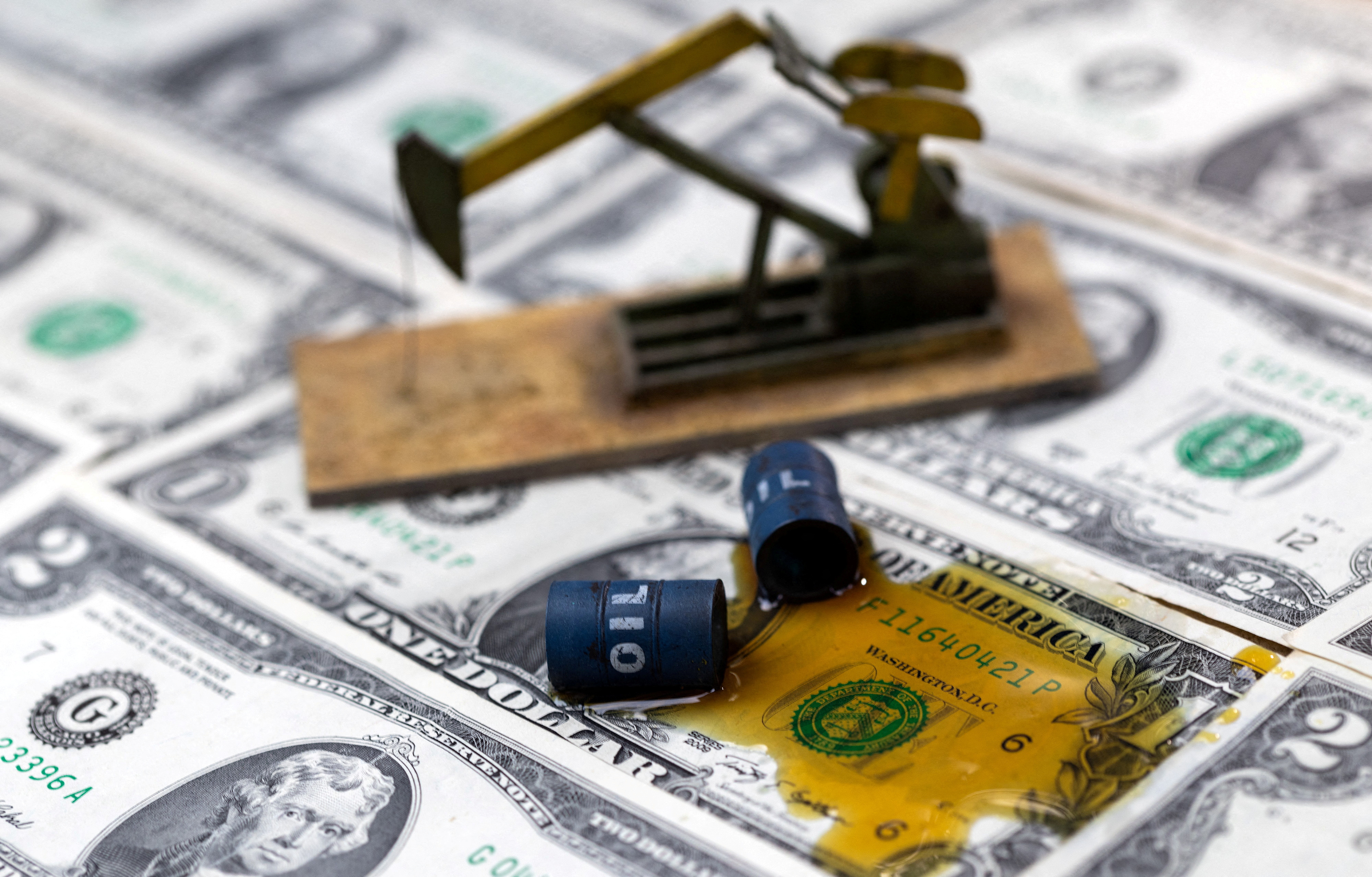 FILE PHOTO: Illustration shows oil, miniatures of oil barrels and U.S. dollar banknote