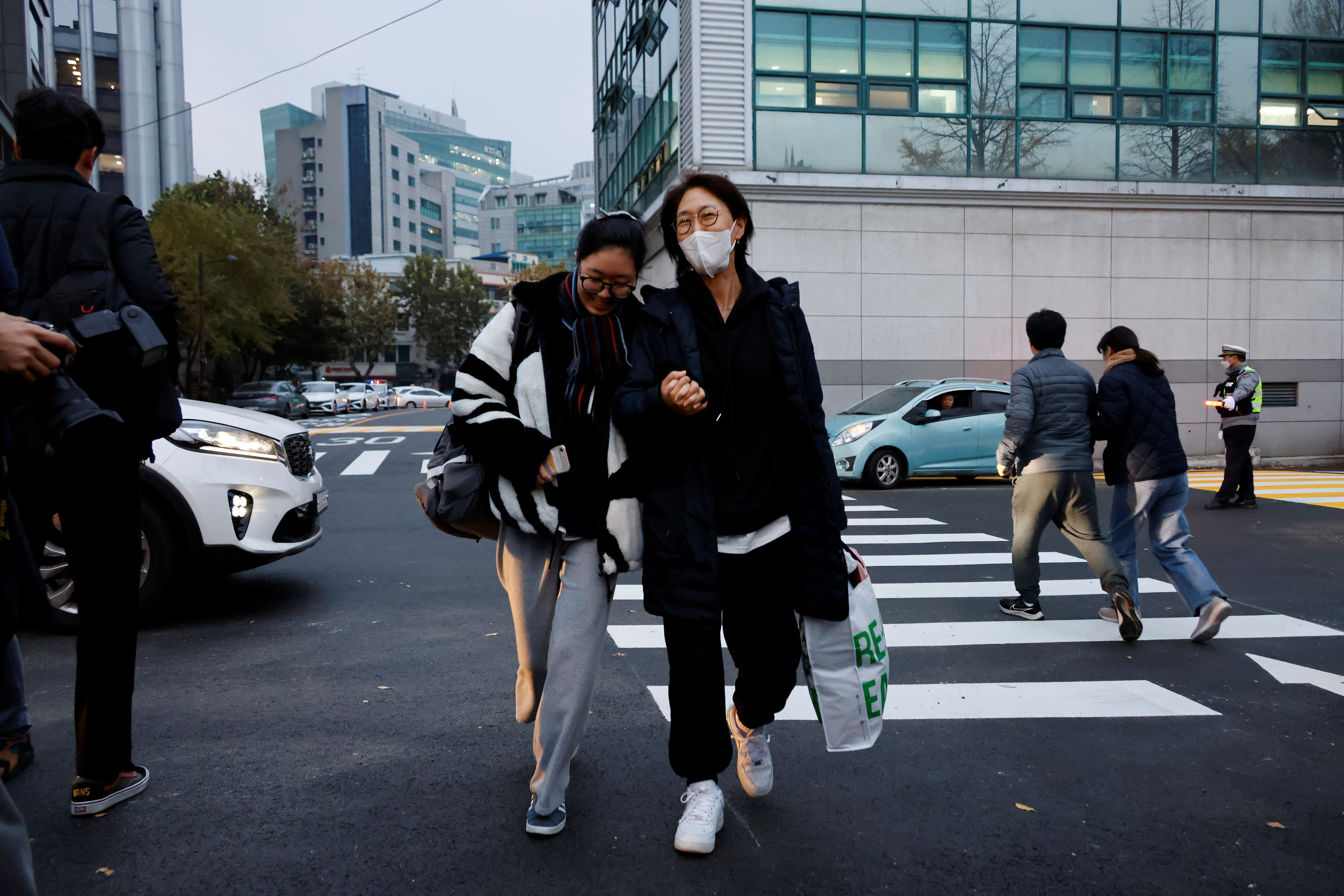 A mother holds her daughter's hand as she takes the College Scholastic Ability Test in Seoul