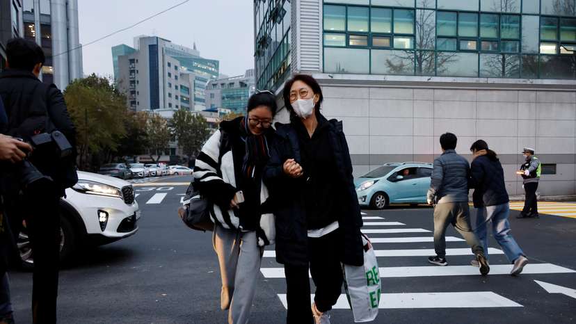 A mother holds her daughter's hand as she takes the College Scholastic Ability Test in Seoul