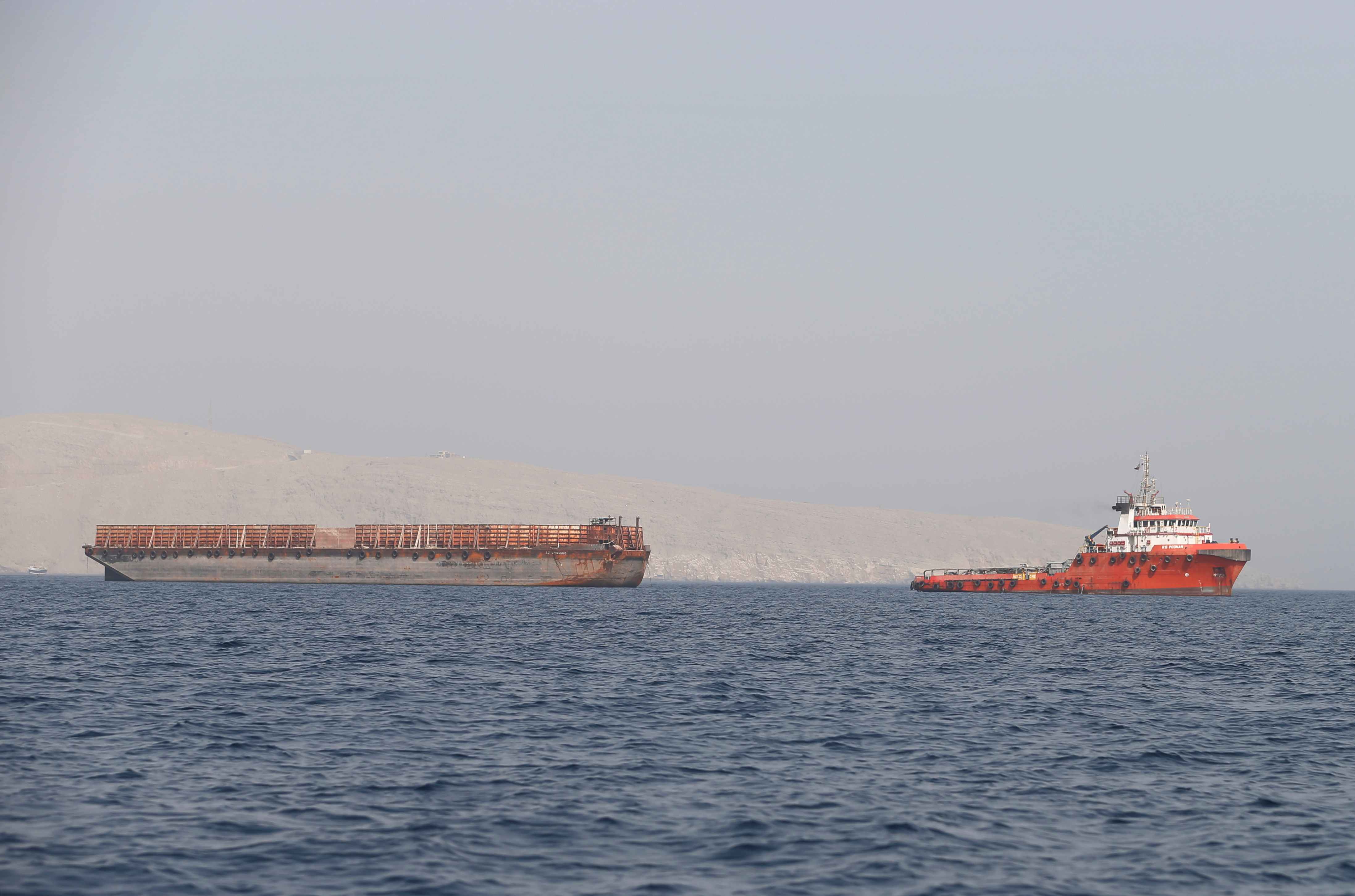 Tug boat moves cargo towards Strait of Hormuz, in Musandam province