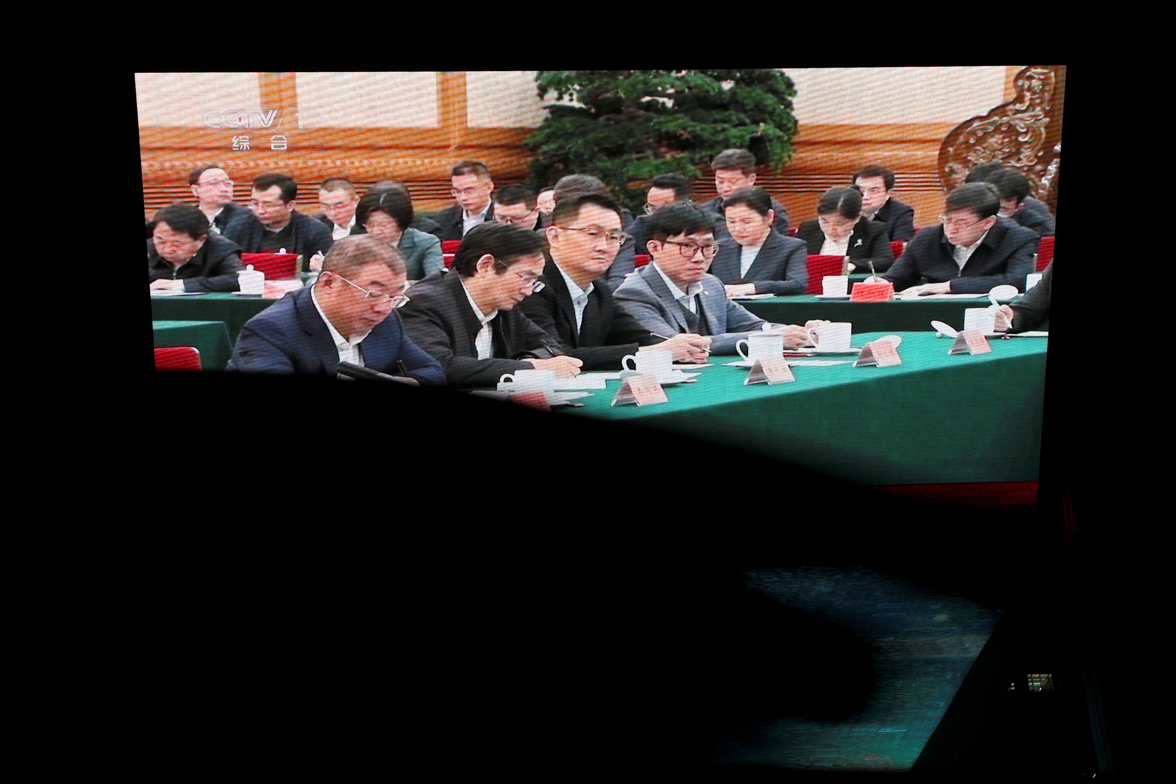 Screen displays news footage of Chinese President Xi Jinping Xi's meeting with business leaders in Beijing