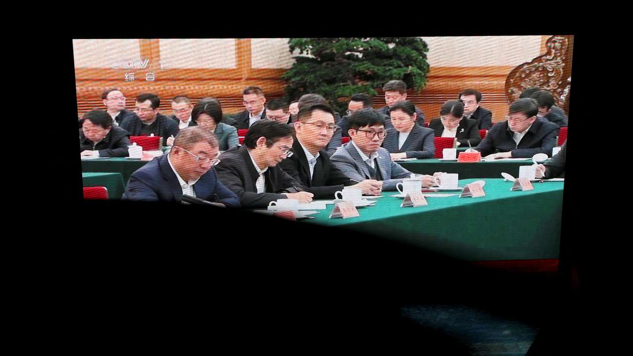 Screen displays news footage of Chinese President Xi Jinping Xi's meeting with business leaders in Beijing