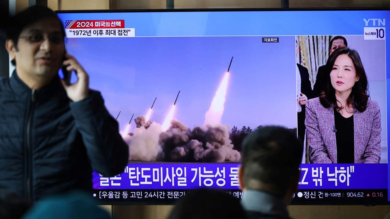 People watch a TV broadcasting a news report on North Korea firing missiles that flew 400 km after lifting off at around 7:30 a.m. from Sariwon, just south of the capital Pyongyang, at a railway station in Seoul