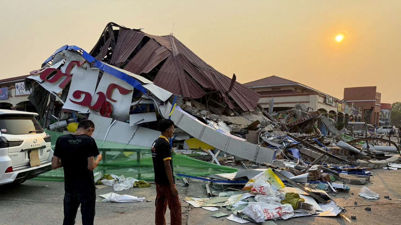 FILE PHOTO: People stand near a commercial facility which collapsed due to an earthquake, in Naypyitaw