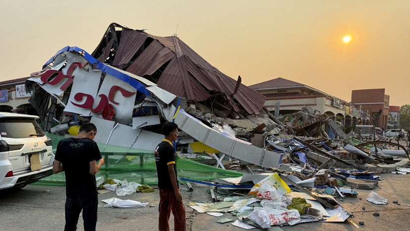 FILE PHOTO: People stand near a commercial facility which collapsed due to an earthquake, in Naypyitaw