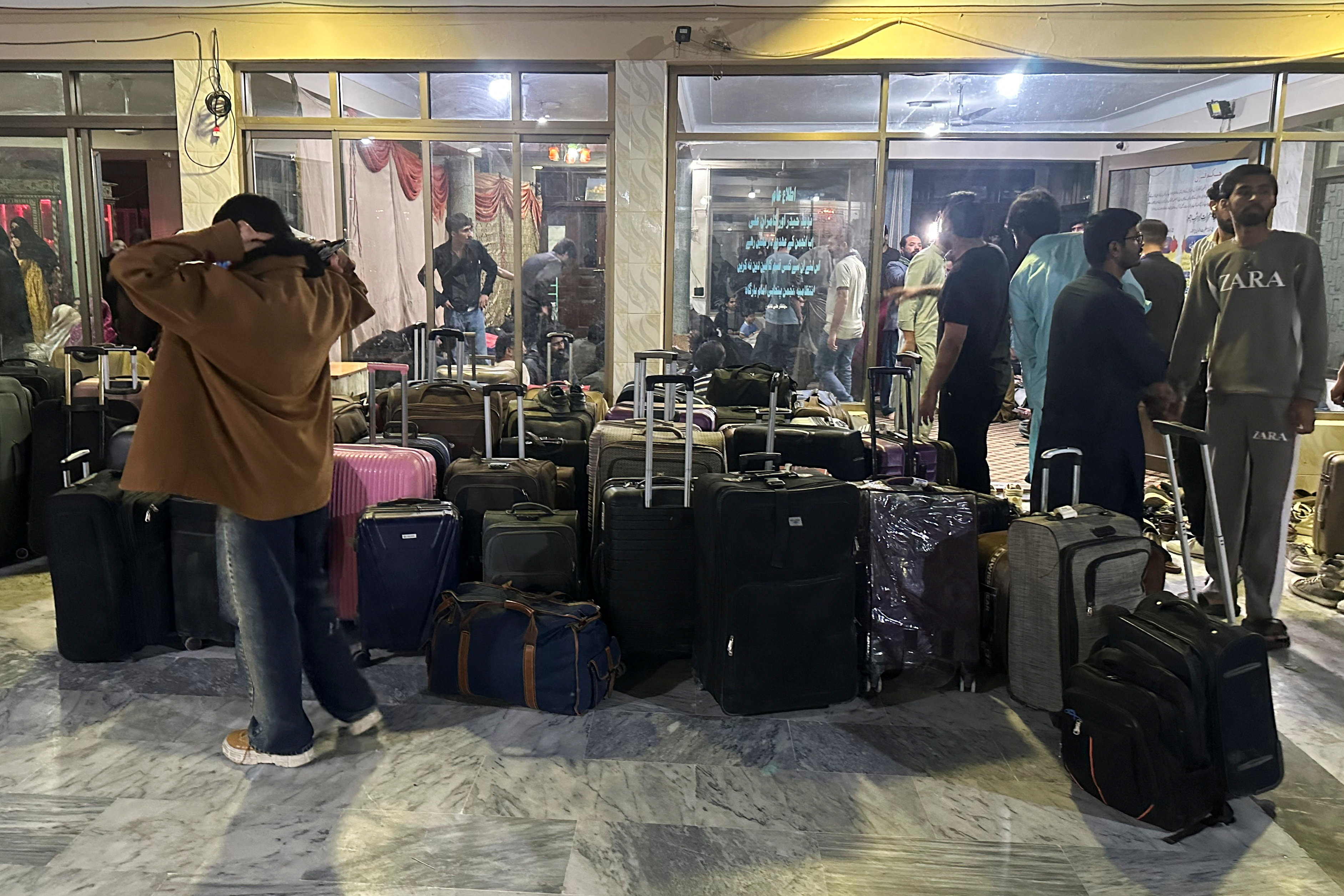 Pakistani students stand next to their luggage after their reutrn from Iran, amid the U.S.-Israeli conflict with Iran, in Quetta