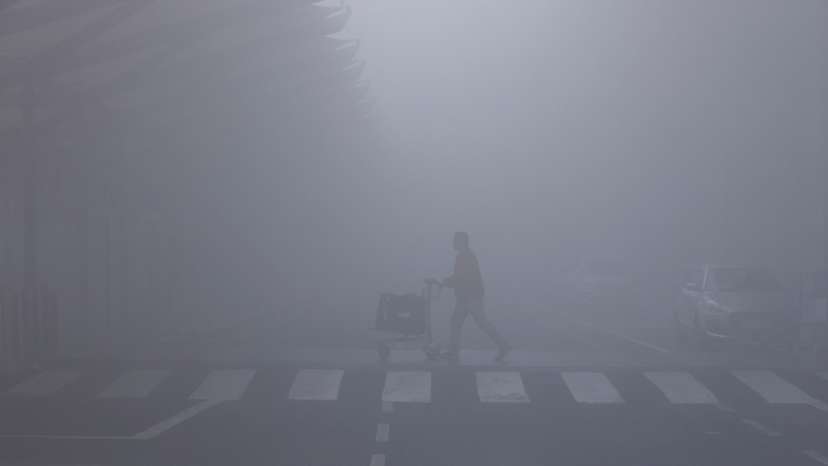 FILE PHOTO: A man walks with his luggage cart amidst heavy fog at the Indira Gandhi International Airport in New Delhi