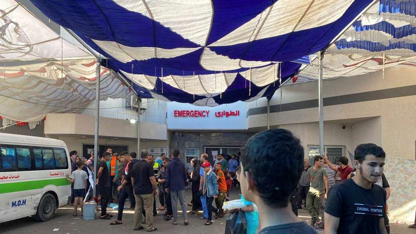 People, including Palestinian children, who fled their house due to Israeli strikes, gather at Al Shifa hospital where they shelter