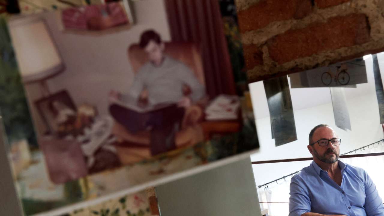 Garcia-Salmones poses at his home next to a picture of himself at the age when he says he was raped by a priest from his school in Madrid