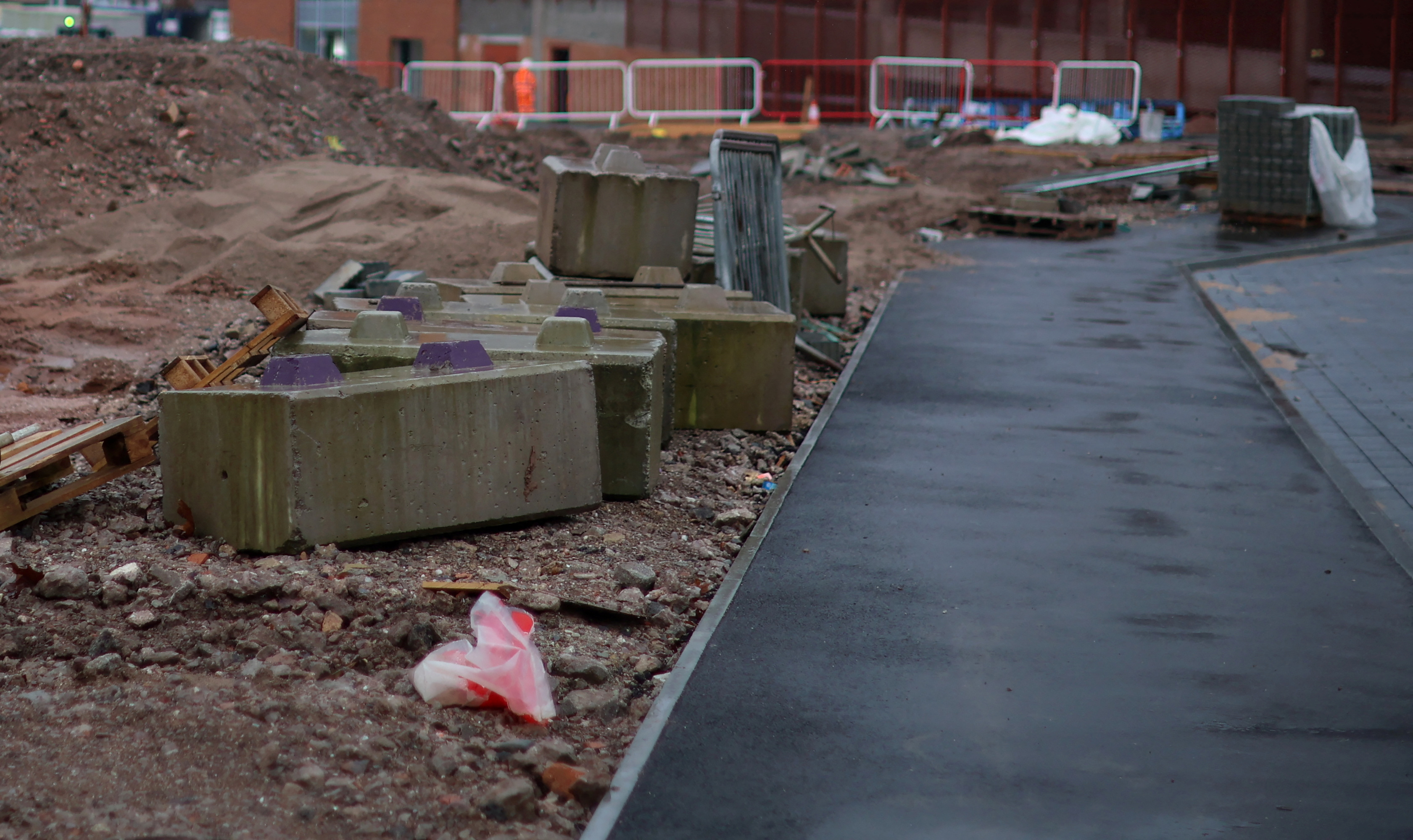A strip of newly laid pavement sits next to a piece of undeveloped land on part of the Royal Arcade development in Crewe