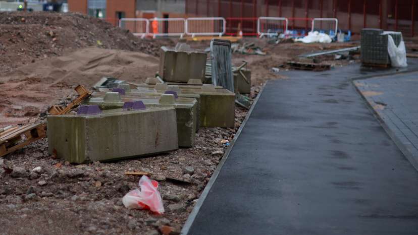 A strip of newly laid pavement sits next to a piece of undeveloped land on part of the Royal Arcade development in Crewe