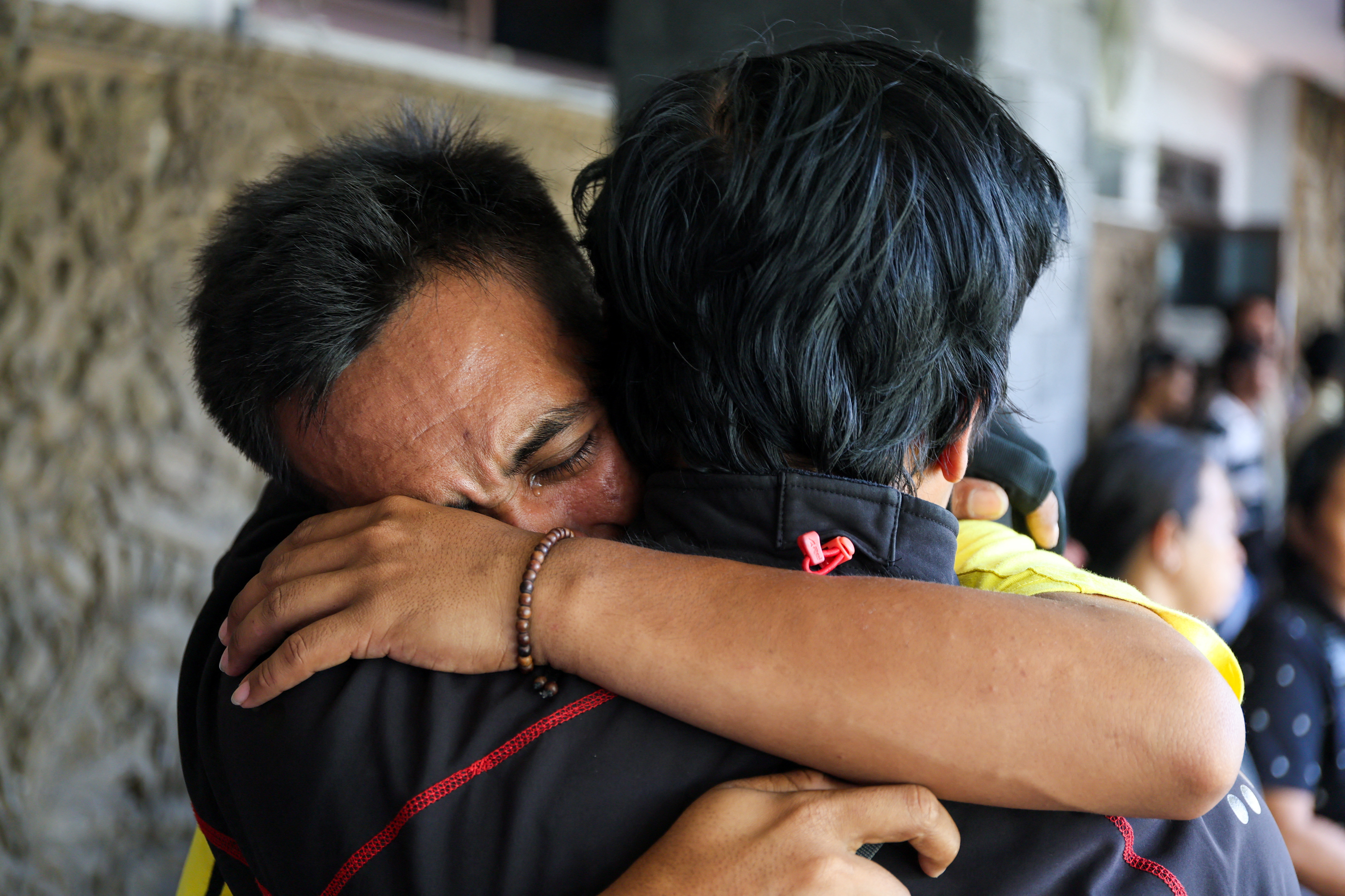 Kholil, 26, a survivor of KMP Tunu Pratama Jaya ferry sinking, reacts as he meets with his relative after a ferry carrying 65 people sank near the Indonesian island of Bali, at Gilimanuk port in Bali