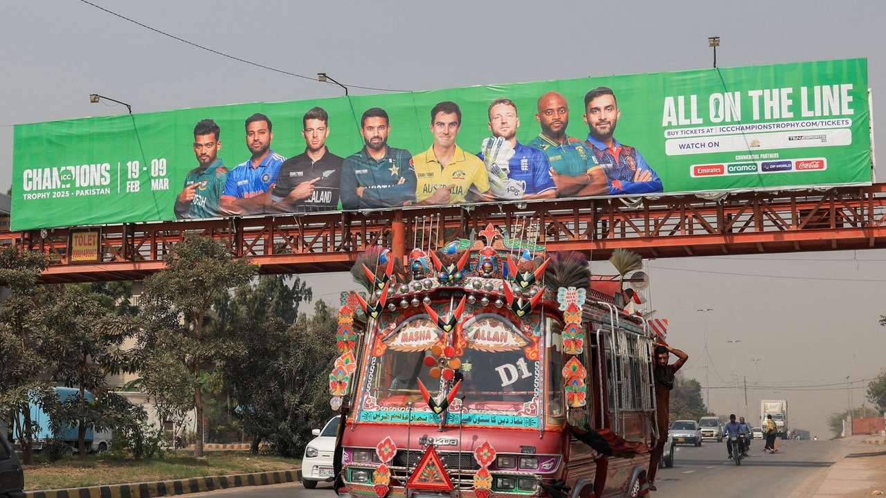 FILE PHOTO: Decorated van drives past under a pedestrian bridge with an advertisment banner ahead of the ICC Champions Trophy 2025 tournament, in Karachi