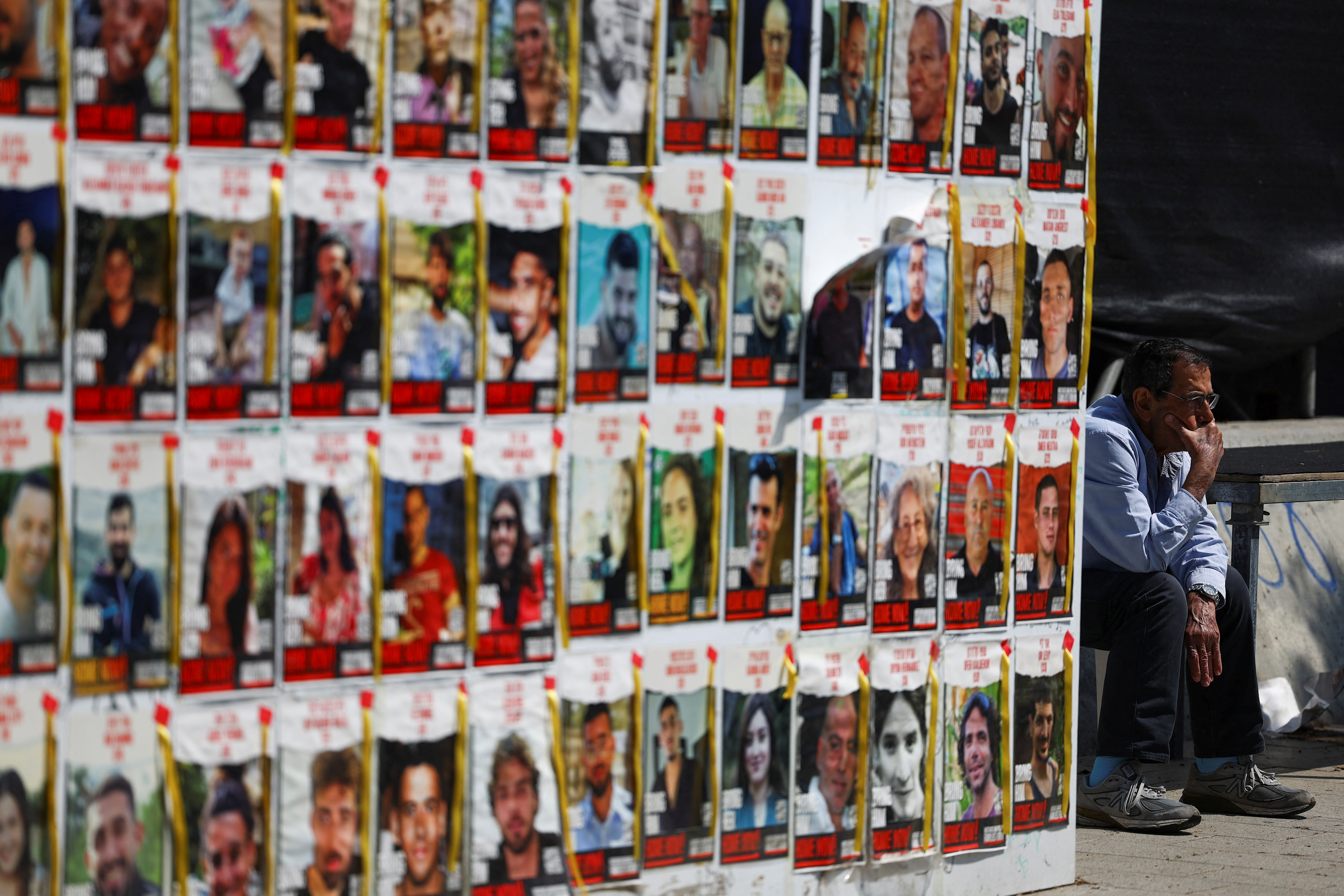 People walk past posters of hostages kidnapped in the October 7 attack by Hamas, in Tel Aviv