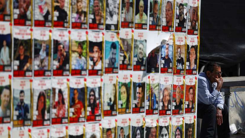 People walk past posters of hostages kidnapped in the October 7 attack by Hamas, in Tel Aviv