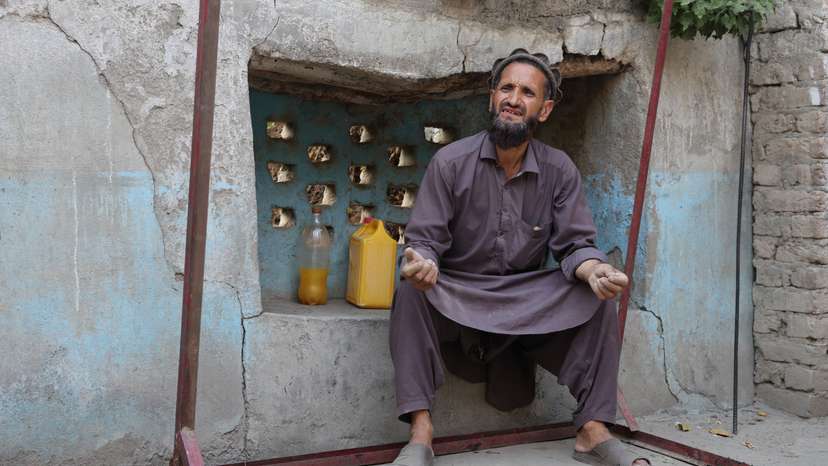 Abdul Ghafar sits at his partially damaged house as he speaks during an interview with Reuters, in Bambakot village