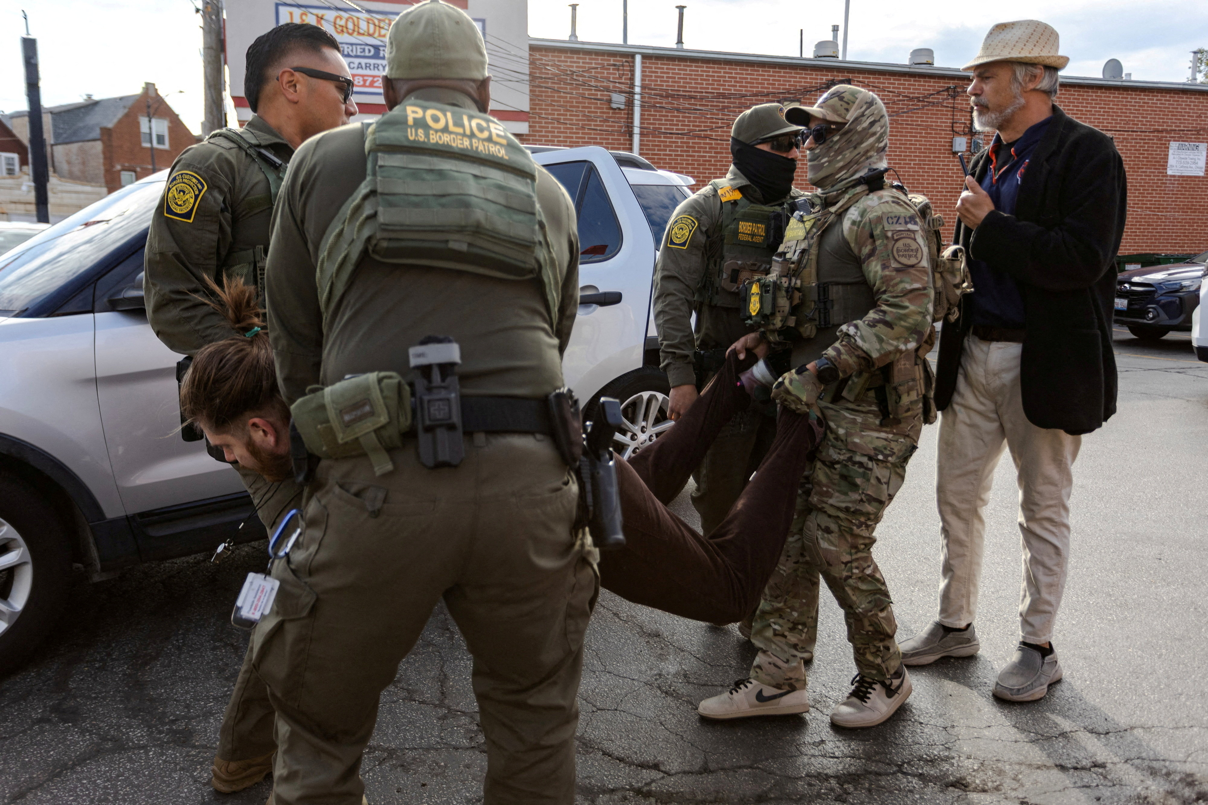 FILE PHOTO: Federal agents in Chicago detain a man after a standoff with community members