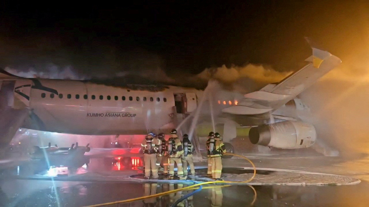 FILE PHOTO: Firefighters try to put out the fire from an Air Busan plane at Gimhae International Airport in Busan