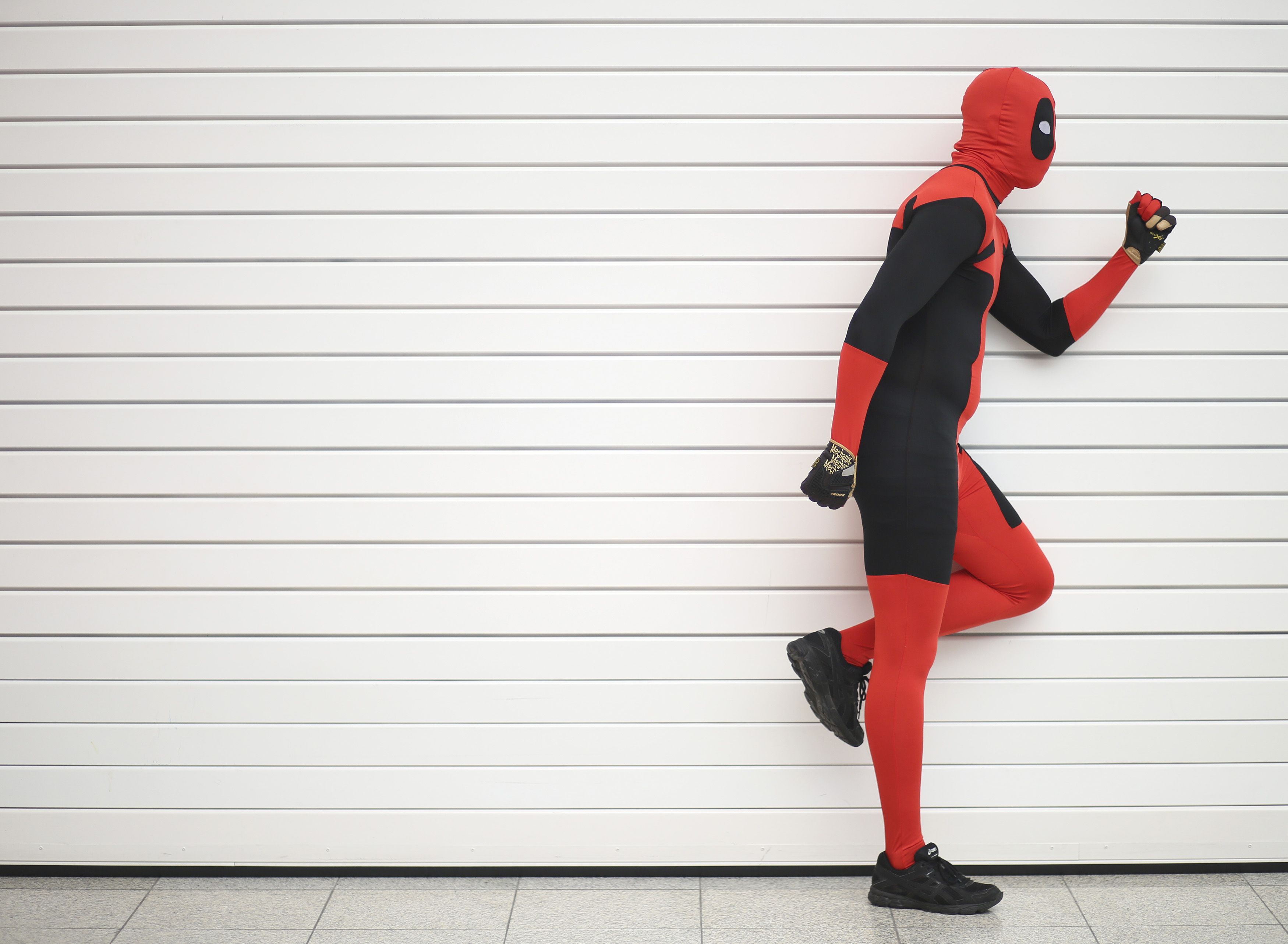 Ricky Santiago dressed as Deadpool from the Marvel comic book poses for a photograph at the London supercomic convention at the Excel centre in east London