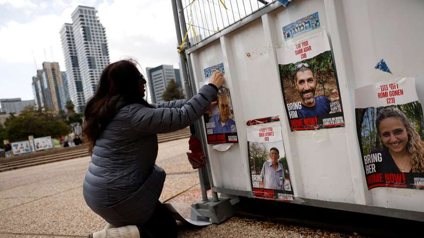 Dahlia Cooper hangs a photo of her father-in-law, kidnapped by Palestinian Islamist group Hamas, in Tel Aviv