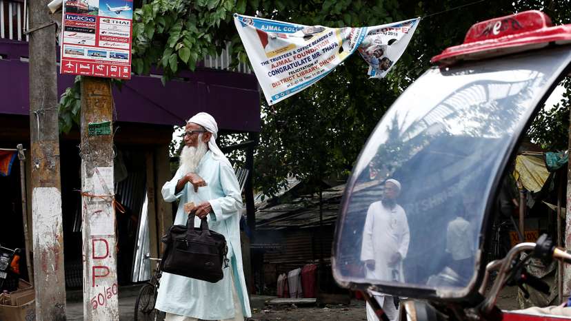 FILE PHOTO: A man walks past an auto rickshaw in Dhubri district, in the northeastern state of Assam