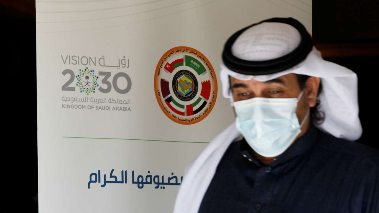 A journalist walks past the logo of the Gulf Cooperation Council (GCC) at the media centre ahead of the 41st summit in Al-Ula