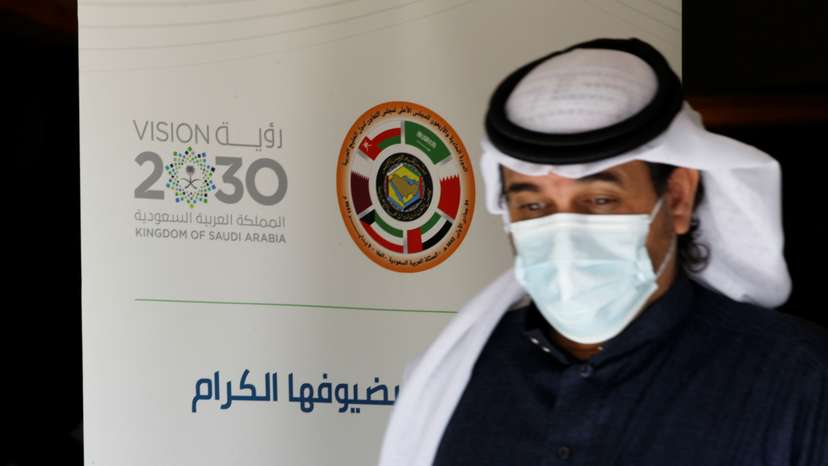 A journalist walks past the logo of the Gulf Cooperation Council (GCC) at the media centre ahead of the 41st summit in Al-Ula