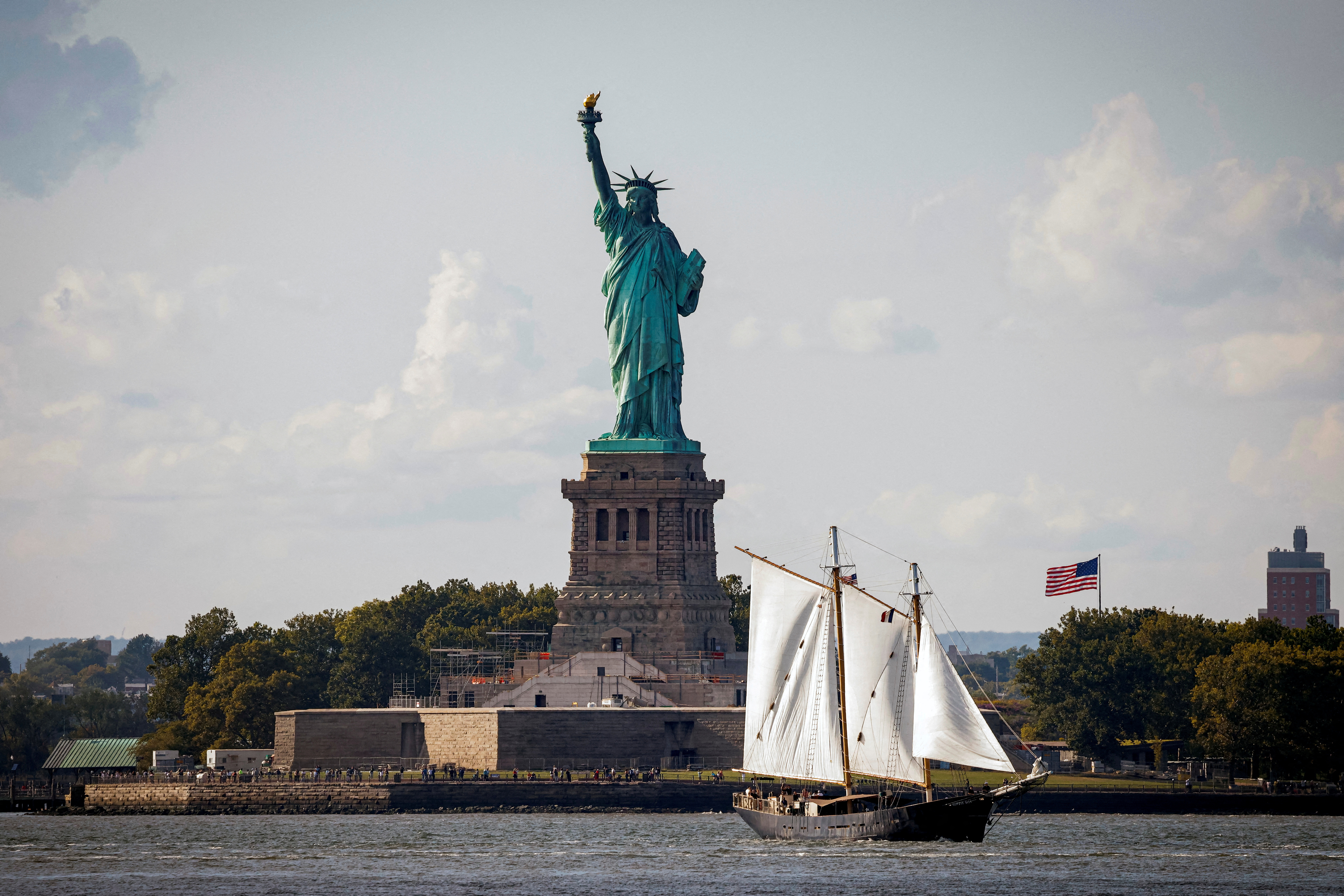 FILE PHOTO: A sailboat passes by the Statue of Liberty in New York Harbor, in New York