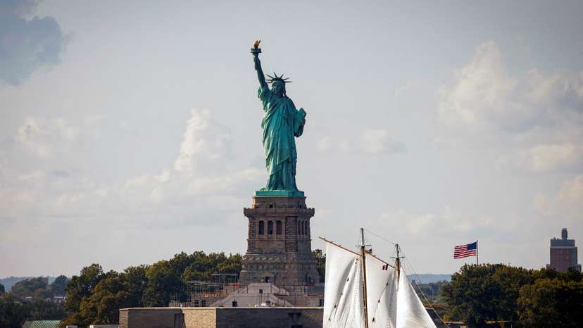 FILE PHOTO: A sailboat passes by the Statue of Liberty in New York Harbor, in New York