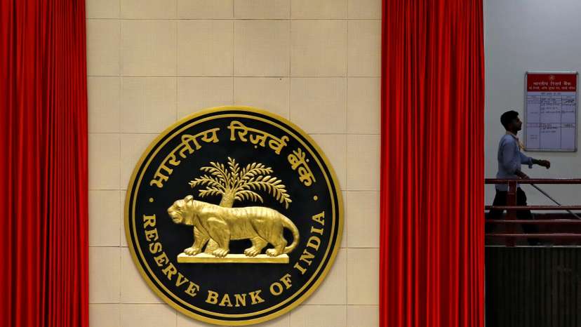 FILE PHOTO: A worker walks past the logo of Reserve Bank of India inside its office in New Delhi