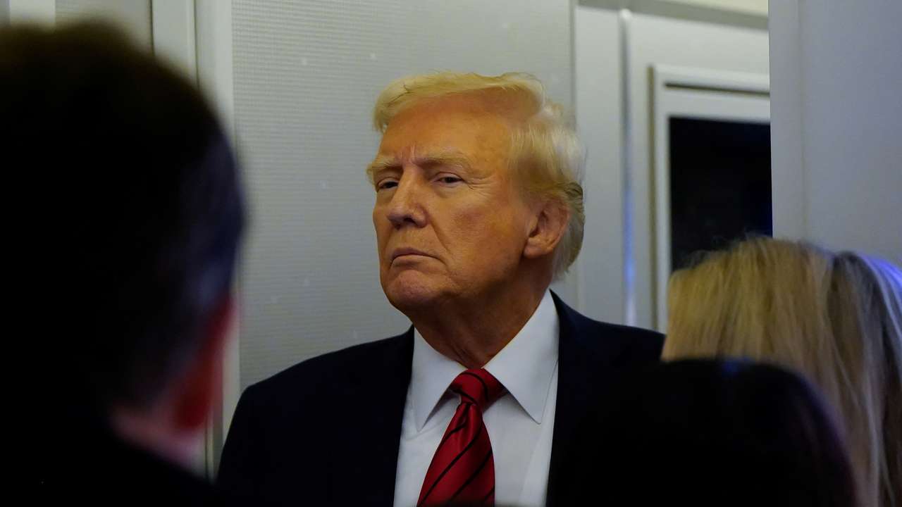 U.S. President Donald Trump speaks to reporters aboard Air Force One