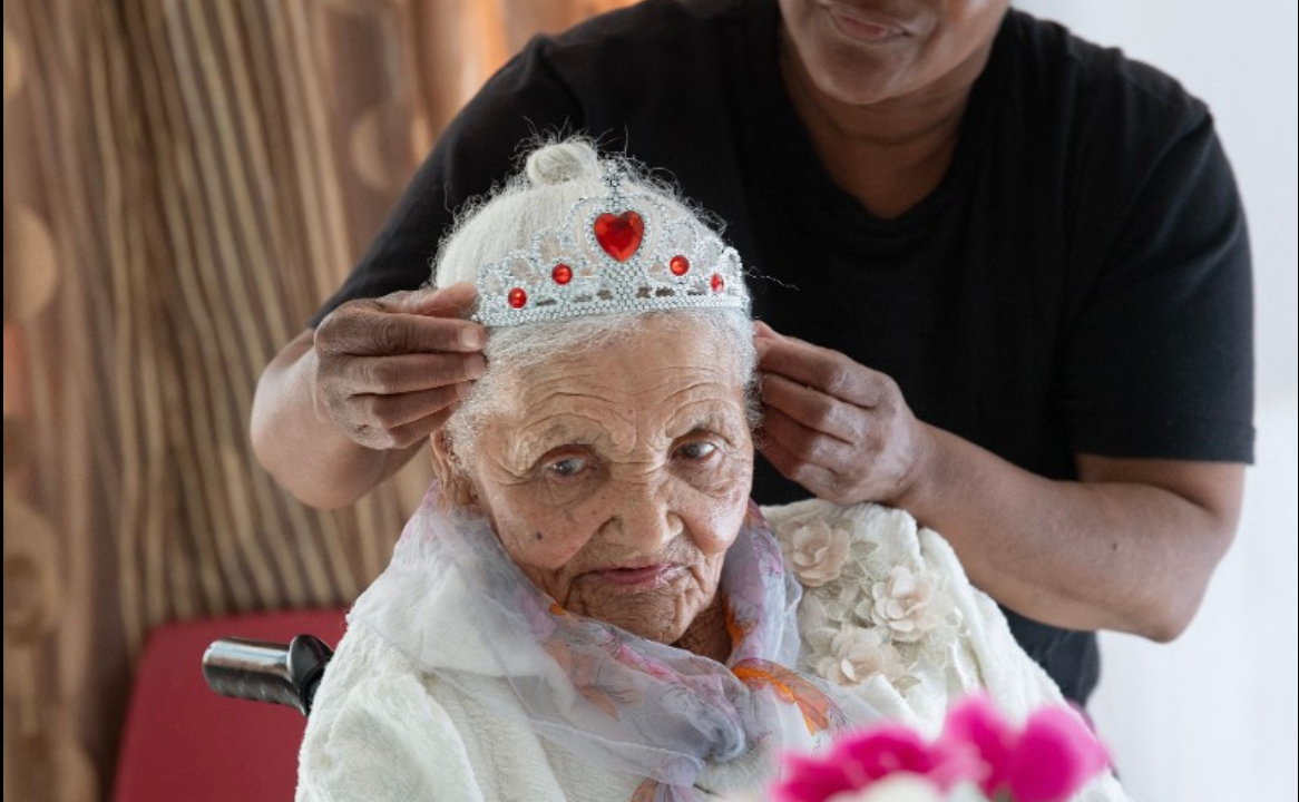 A carer puts a a tiara on Margaret Maritz (L) as she celebrates her 118 birthday in an old-age home in Touwsrivier on September 27, 2024