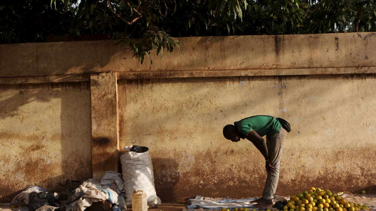 A fruit vendor prays on the side of a street in Bamako