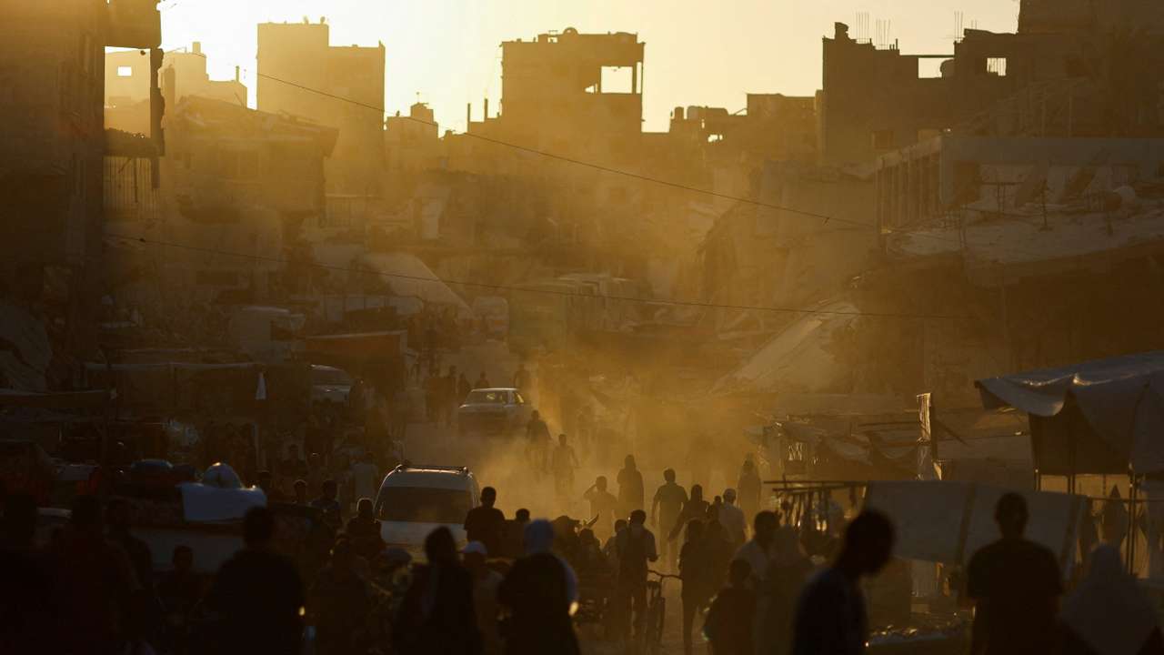 People walk at the remains of a market after an Israeli strike, in Khan Younis