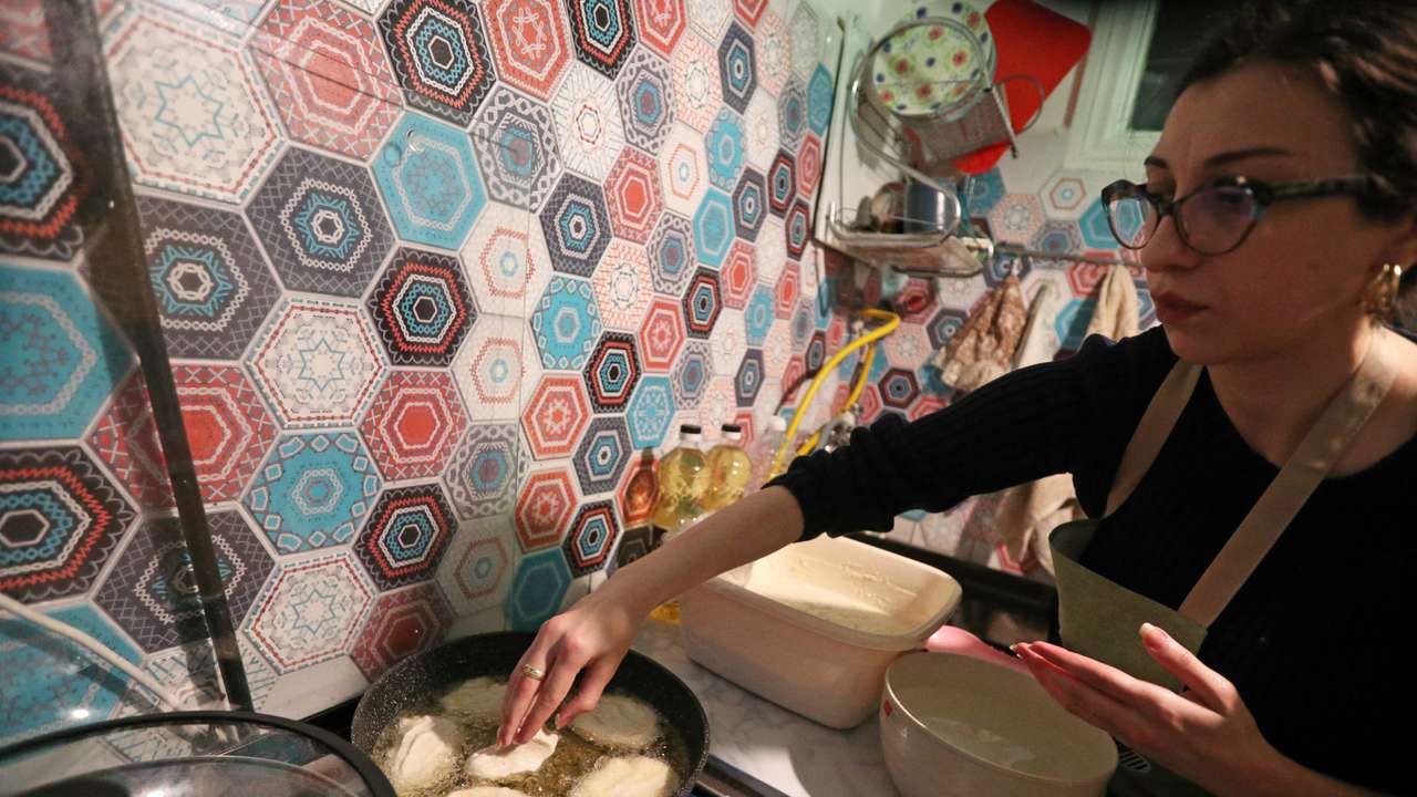 Artist Gogona Parkaia cooks traditional Georgian cornbread for her fellow demonstrators in Tbilisi