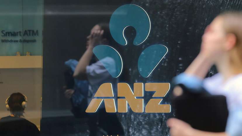 A pedestrian is reflected in the window of a branch of the Australia and New Zealand Banking Group (ANZ) in central Sydney