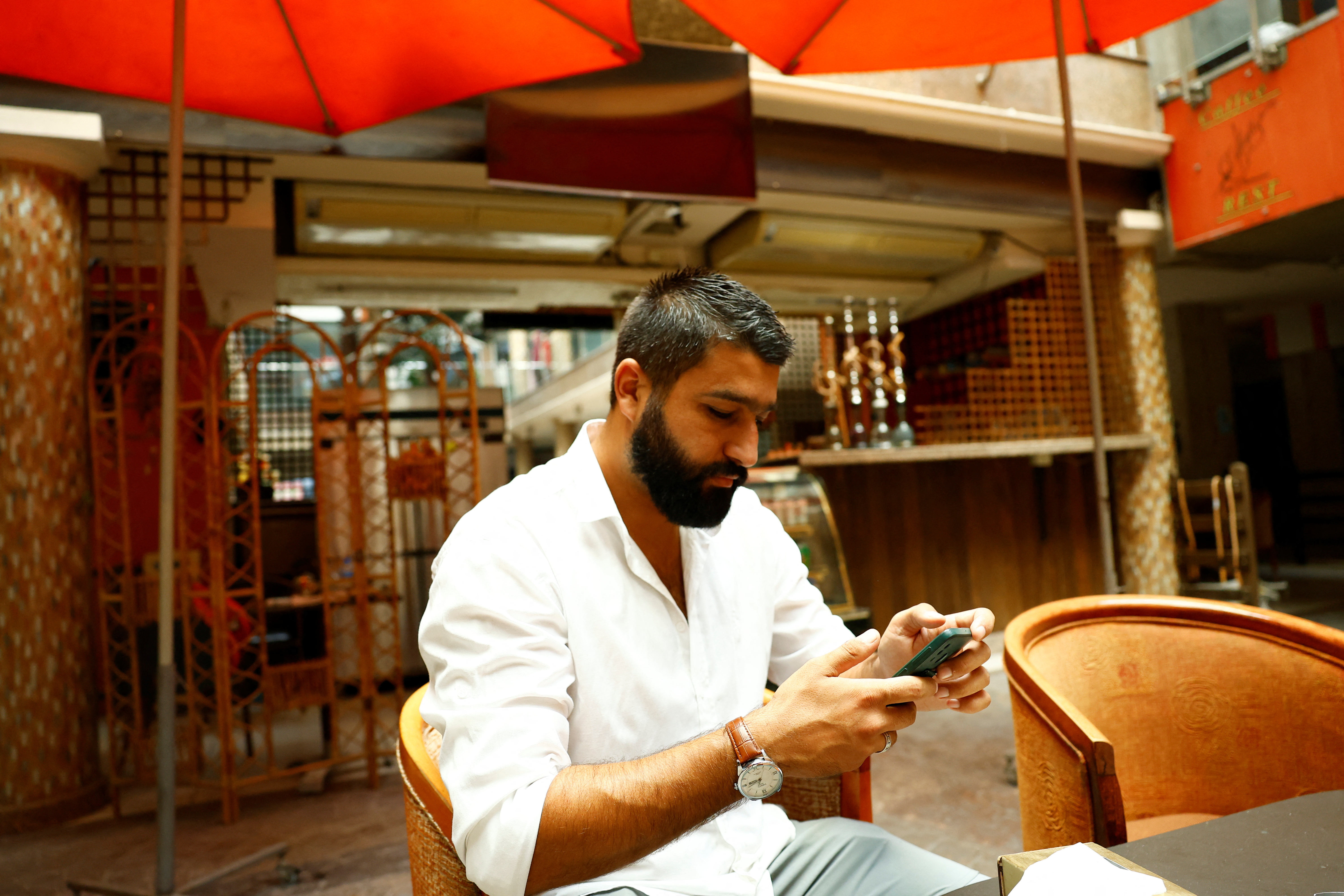 Khairallah Dib sits inside his coffee shop in Qurdaha, in the Latakia countryside