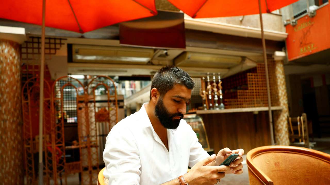 Khairallah Dib sits inside his coffee shop in Qurdaha, in the Latakia countryside