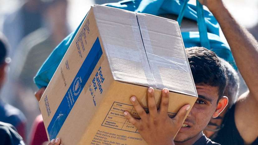 Palestinians carry aid that entered Gaza, in Zawaida
