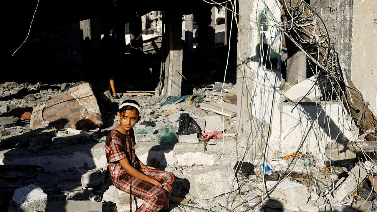 Palestinians react at the site of an Israeli strike on a house, in Rafah