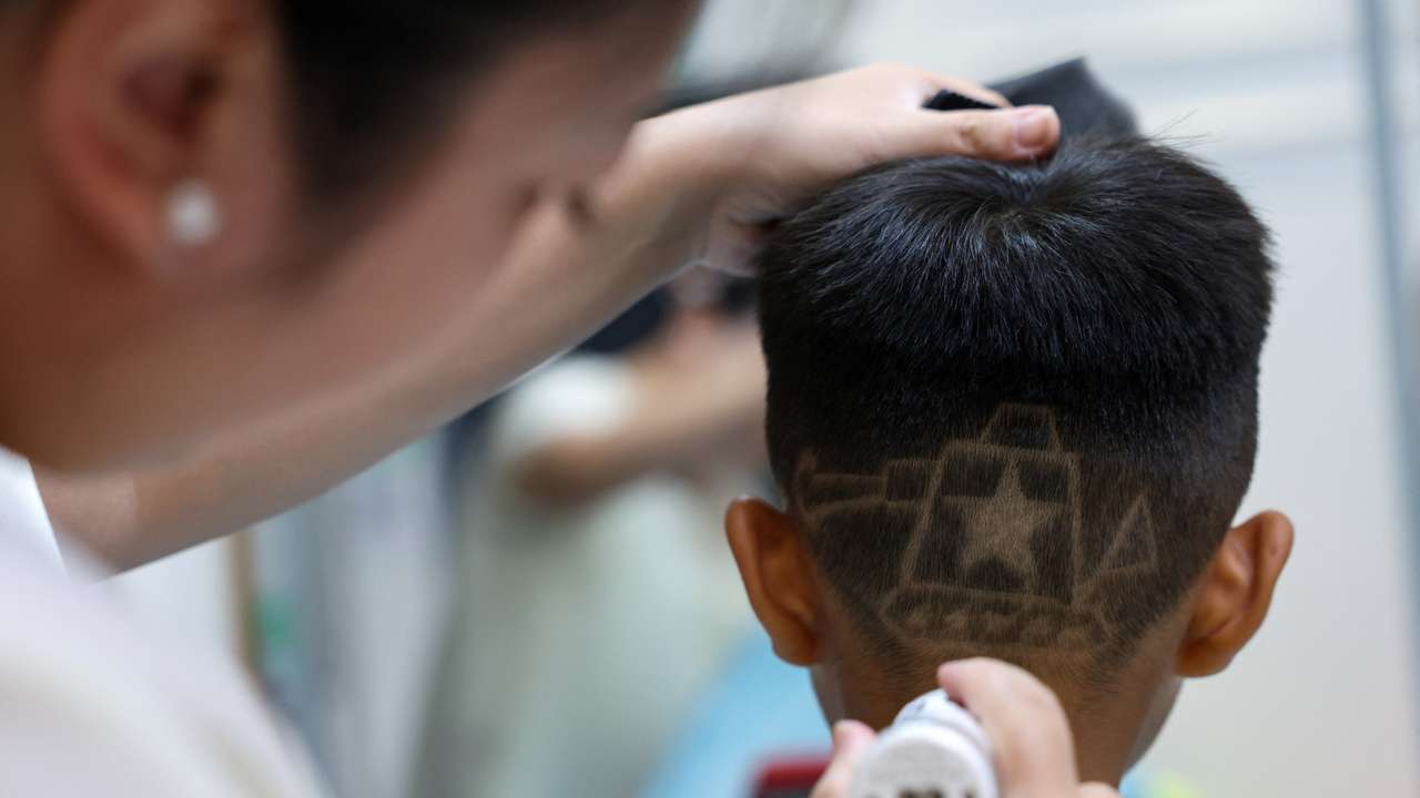 Hair salon owner Xueru gives a child a haircut in a design of a tank to commemorate the 80th anniversary of the end of World War Two in Beijing