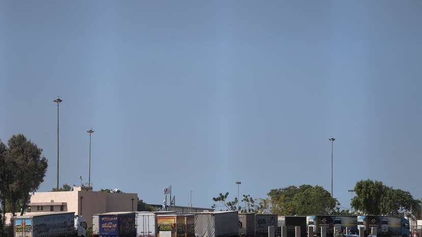 Trucks carrying aid wait at the Israeli side of the Kerem Shalom border crossing to southern Gaza
