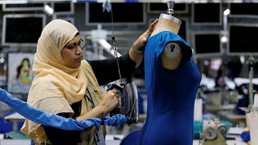 A woman irons a dress at Timex garments factory in Wattala