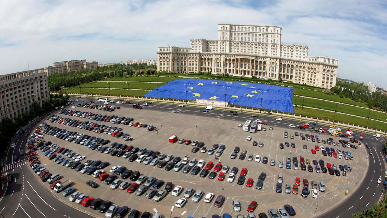 A large European Union flag is displayed in front of Romania's Parliament Building to mark EU Day in Bucharest