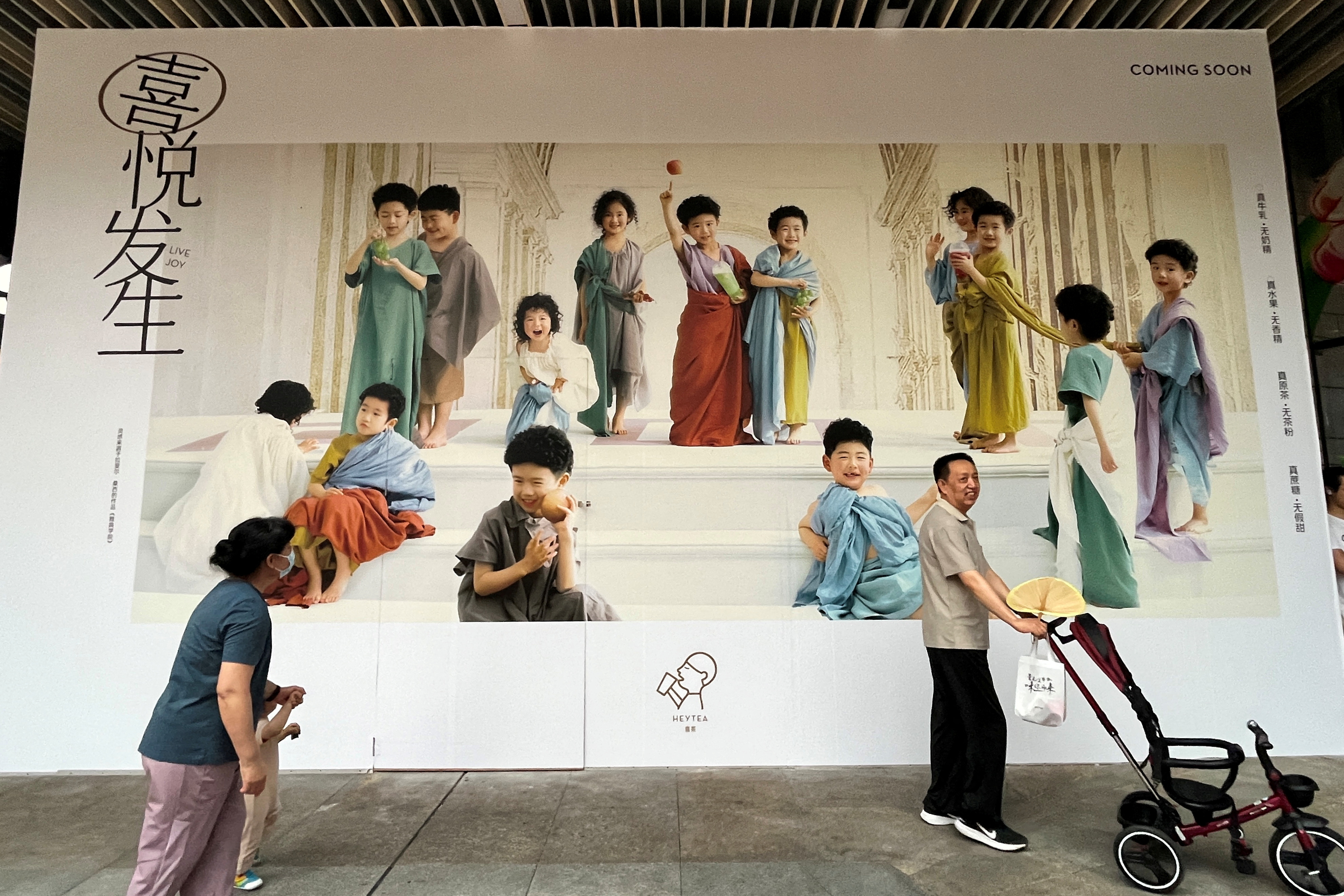 People walk past a billboard in Shenzhen